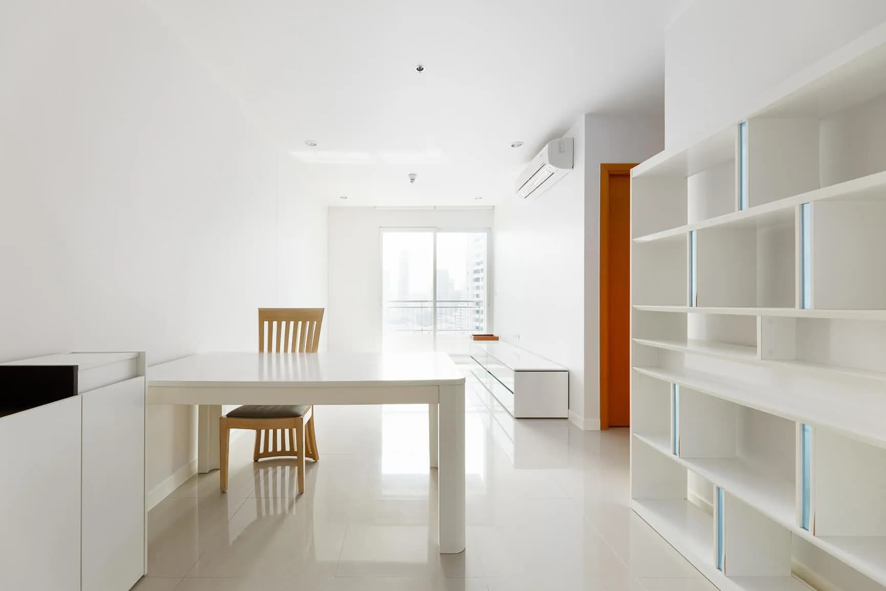Circle Condominium living room with dining table, built-in shelving, and balcony light